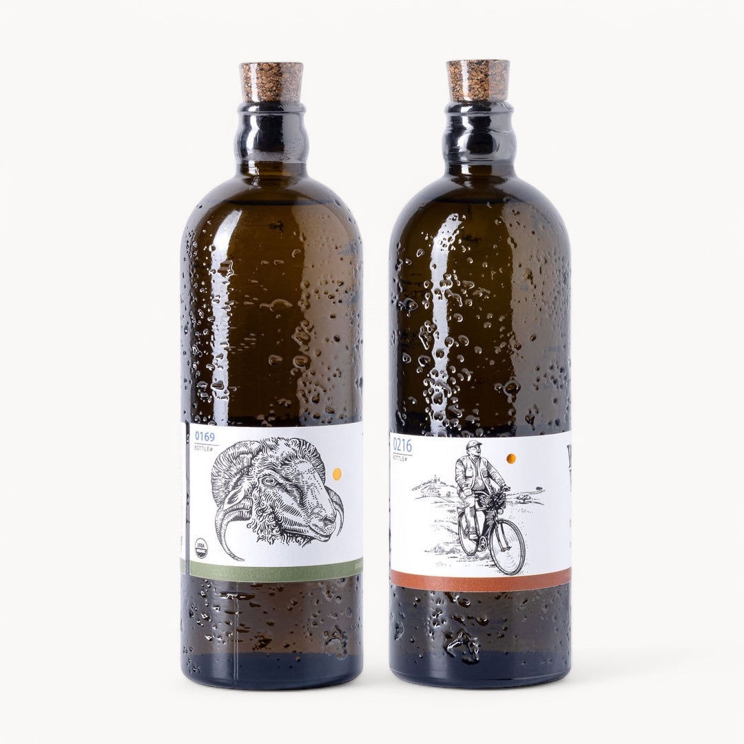 Two bottles of Portuguese olive oil from the Explorer Set, showcasing unique labels and amber glass.