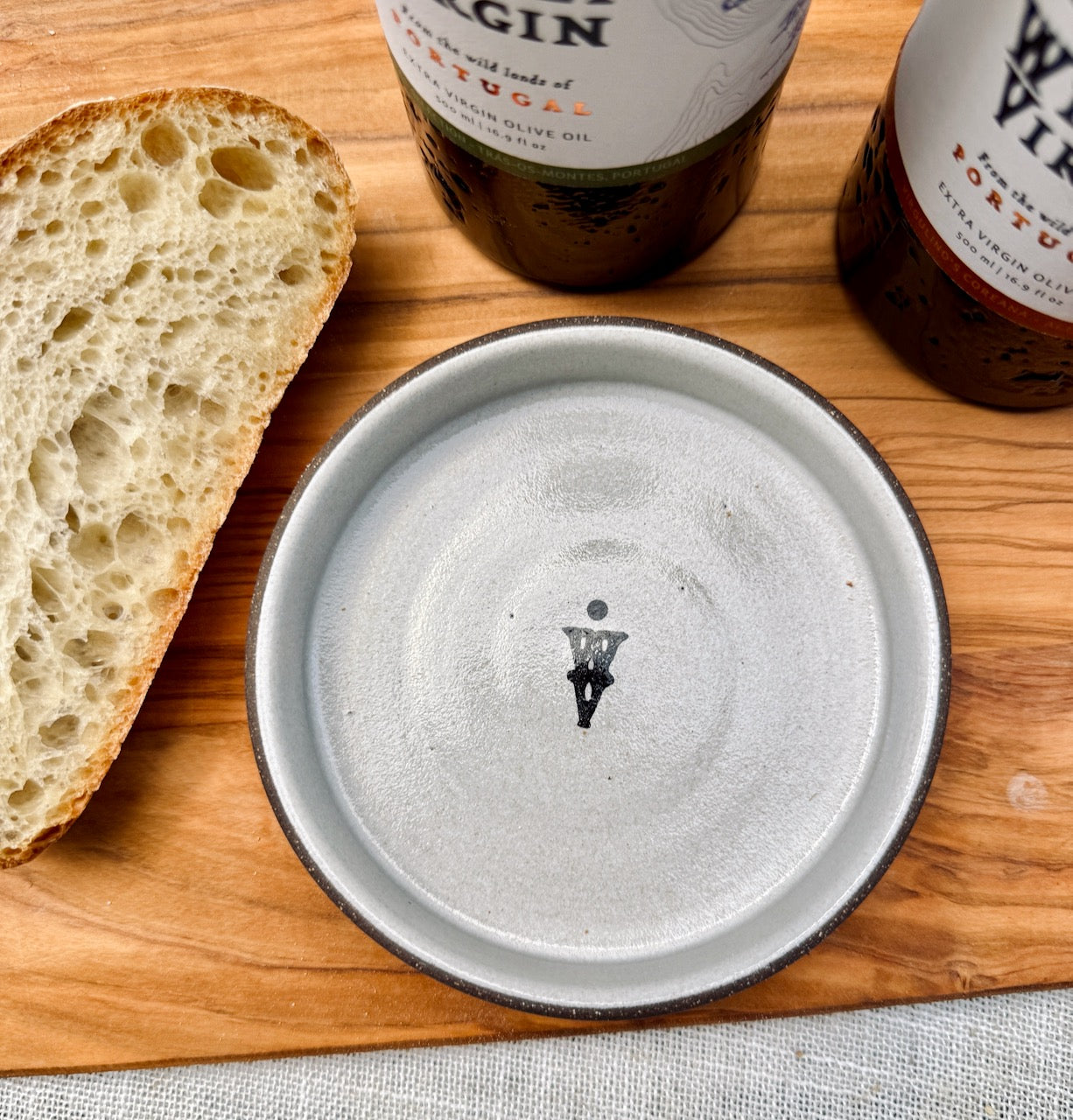 Tour of Portugal Gift Set featuring a hand-turned olive oil dish with artisan details and fresh bread on a wooden board.