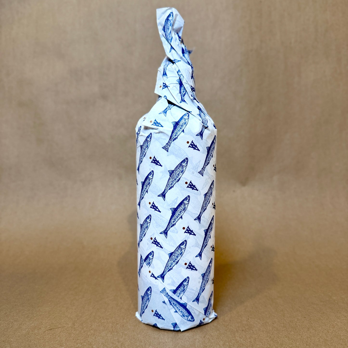 Artfully wrapped bottle featuring blue fish design, showcasing a unique packaging style.