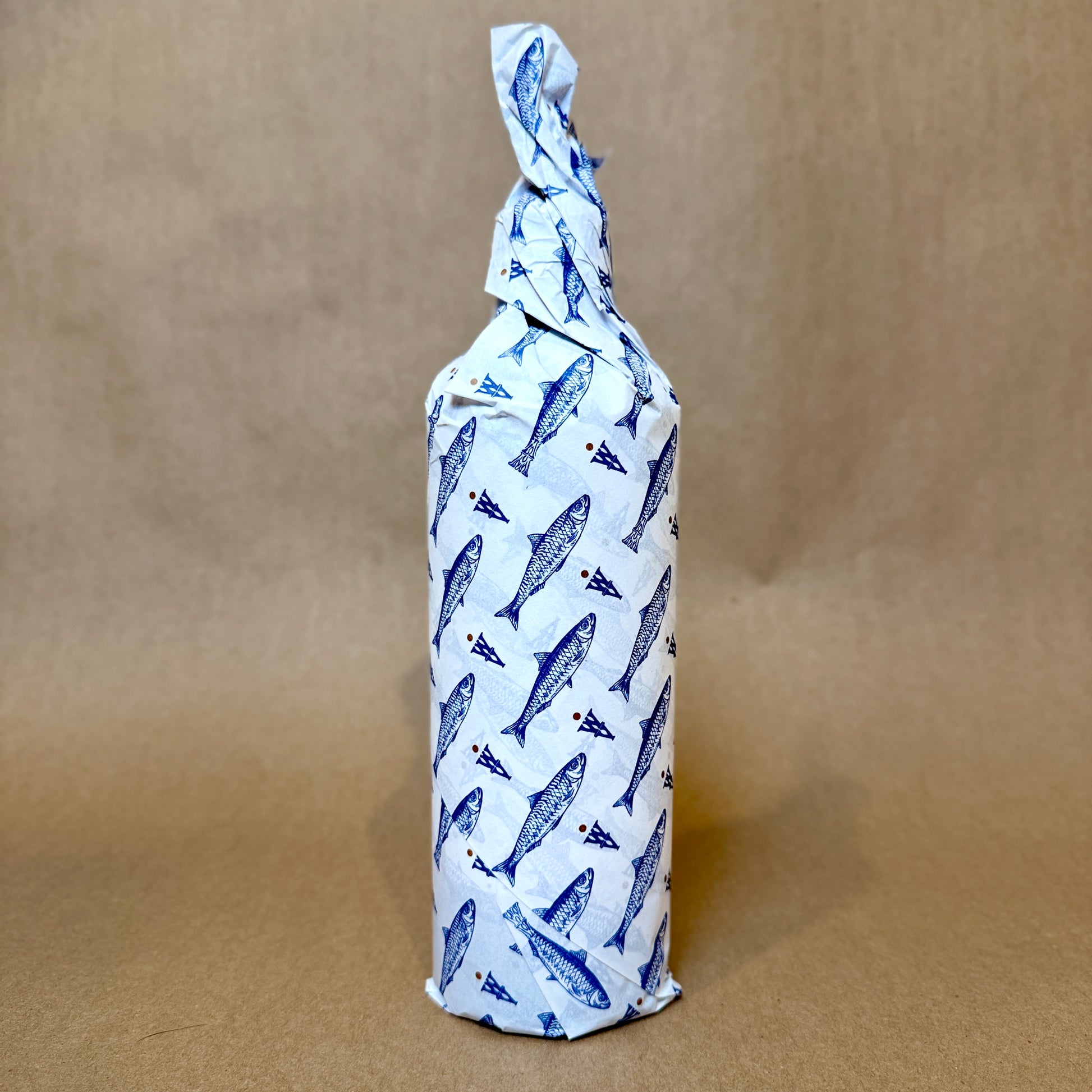 Artfully wrapped bottle featuring blue fish design, showcasing a unique packaging style.