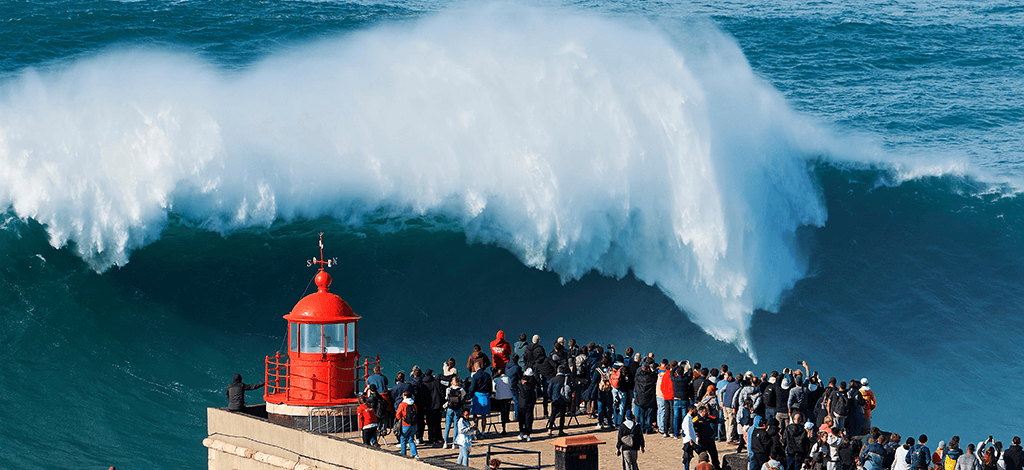 A huge wave crashing in Nazare with surfer