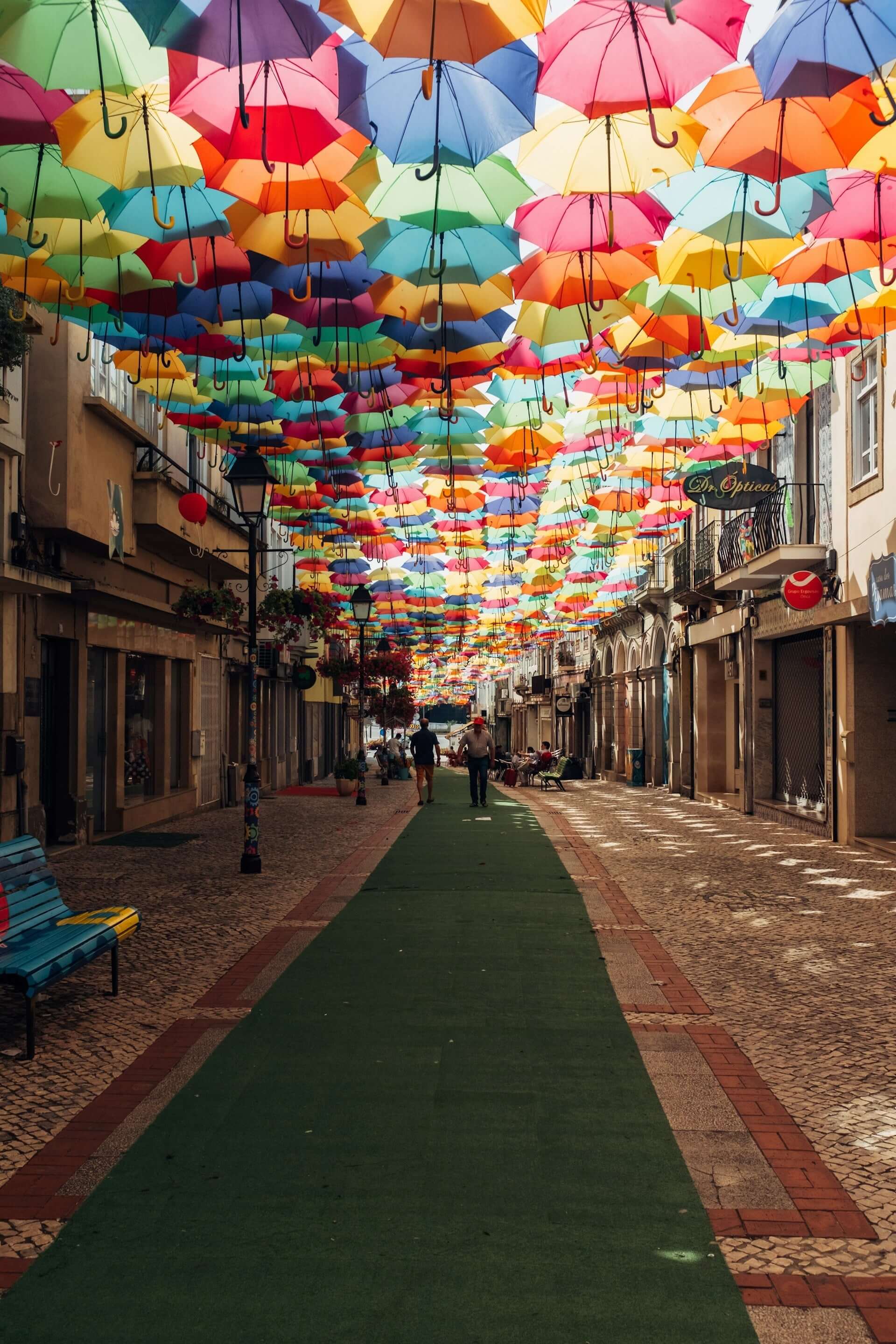 Colorful umbrellas over a Portuguese cobblestone street