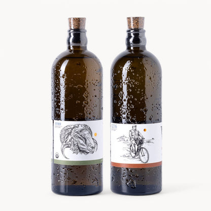 Two bottles of Portuguese olive oil from the Explorer Set, showcasing unique labels and amber glass.