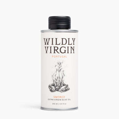 A 250ml metal can of Wildly Virgin Smoked Extra Virgin Olive Oil from Portugal, featuring a white label with a black cap and a campfire illustration.