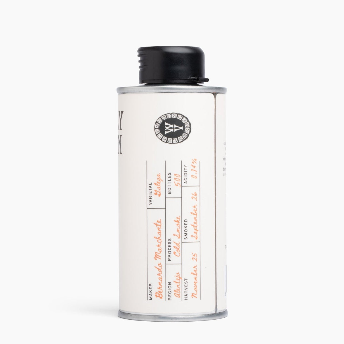 A vintage-style metal canister with a black screw cap, featuring a cream-colored label with handwritten details and a circular logo, set against a plain white background.