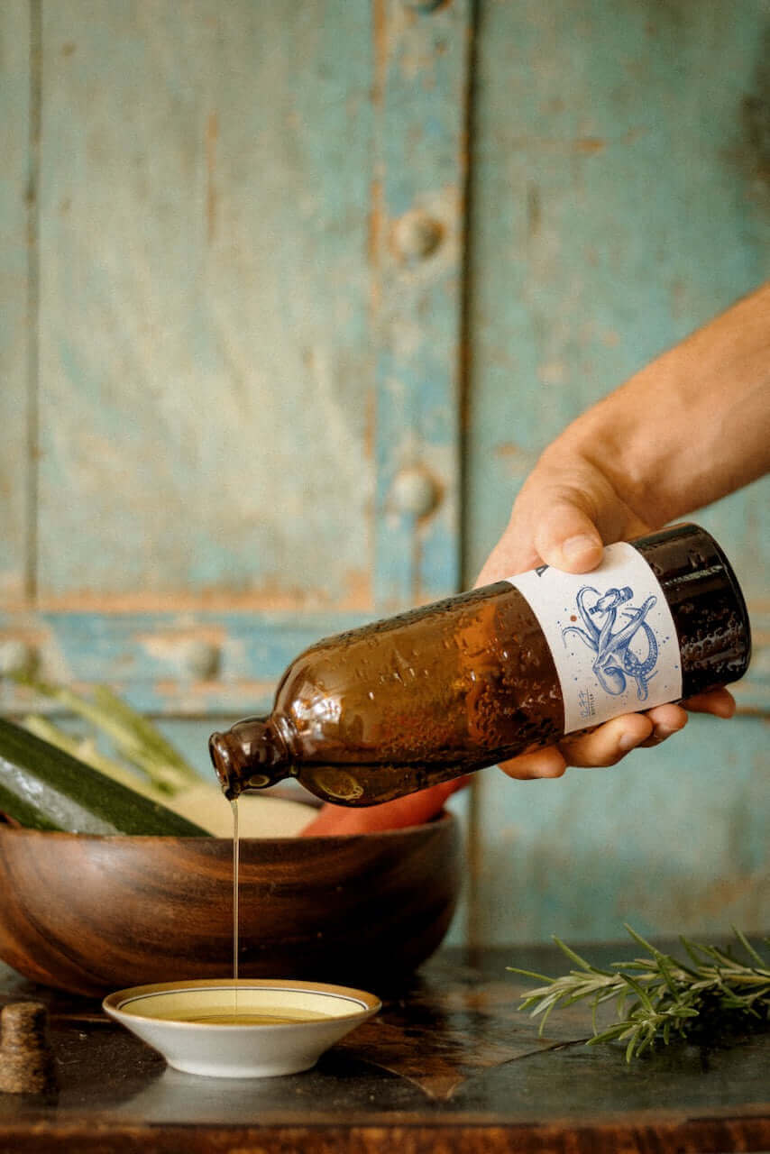 Extra virgin olive oil pouring on salad.