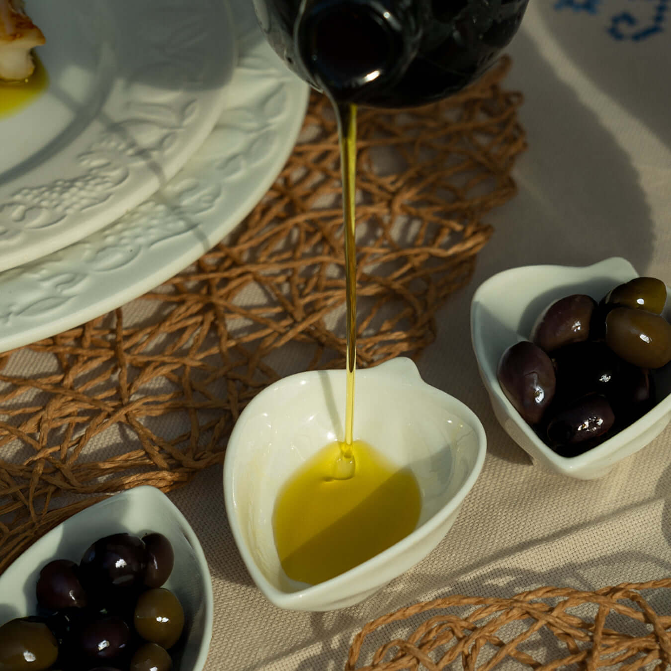 Pouring Doce olive oil into a heart-shaped dish with olives, highlighting its fruity essence.