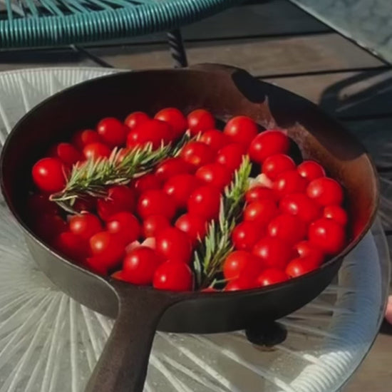 Wildly Virgin olive oil being poured over tomatoes and rosemary